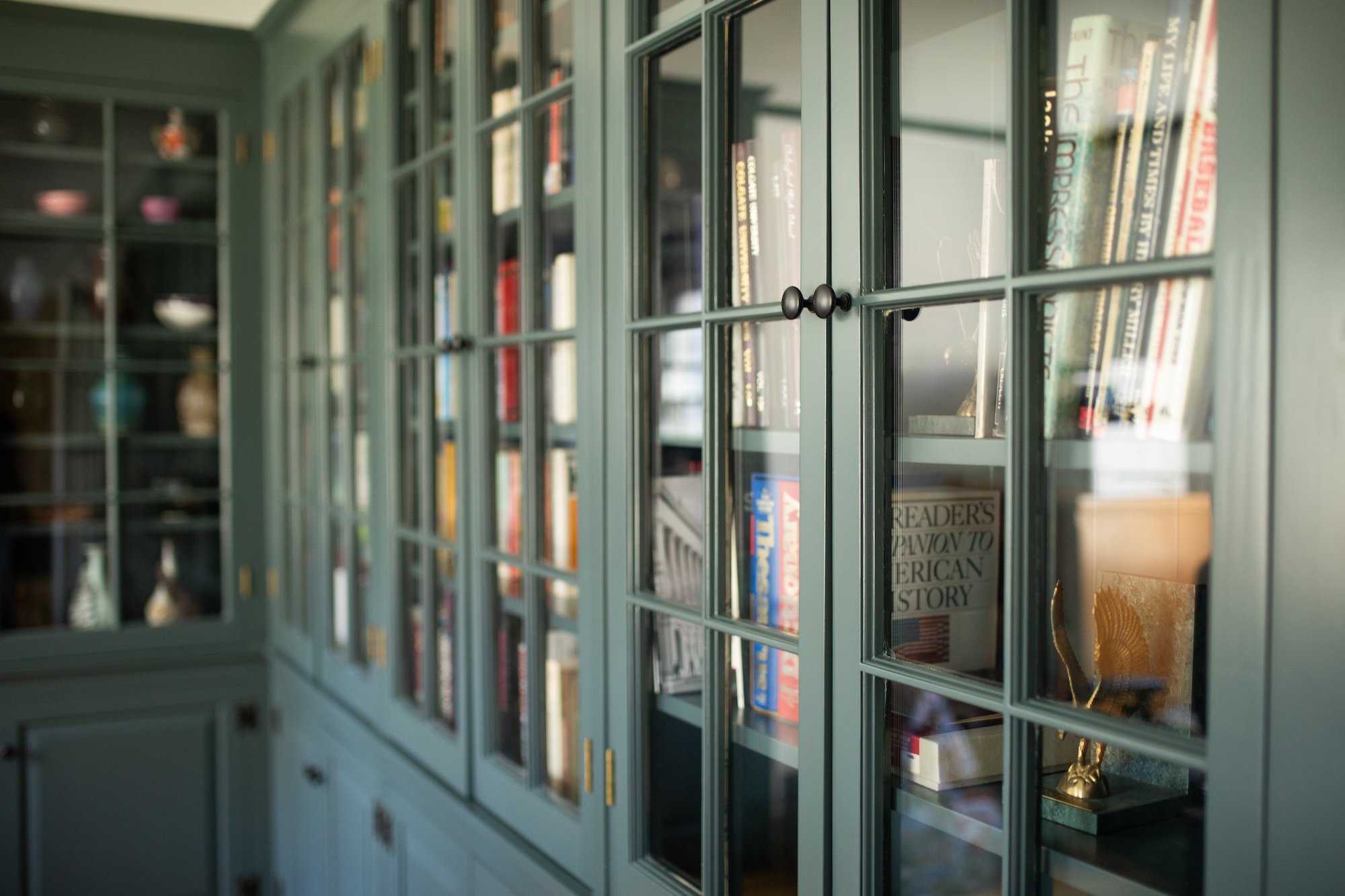 Close-up view of built-in cabinets painted dark green