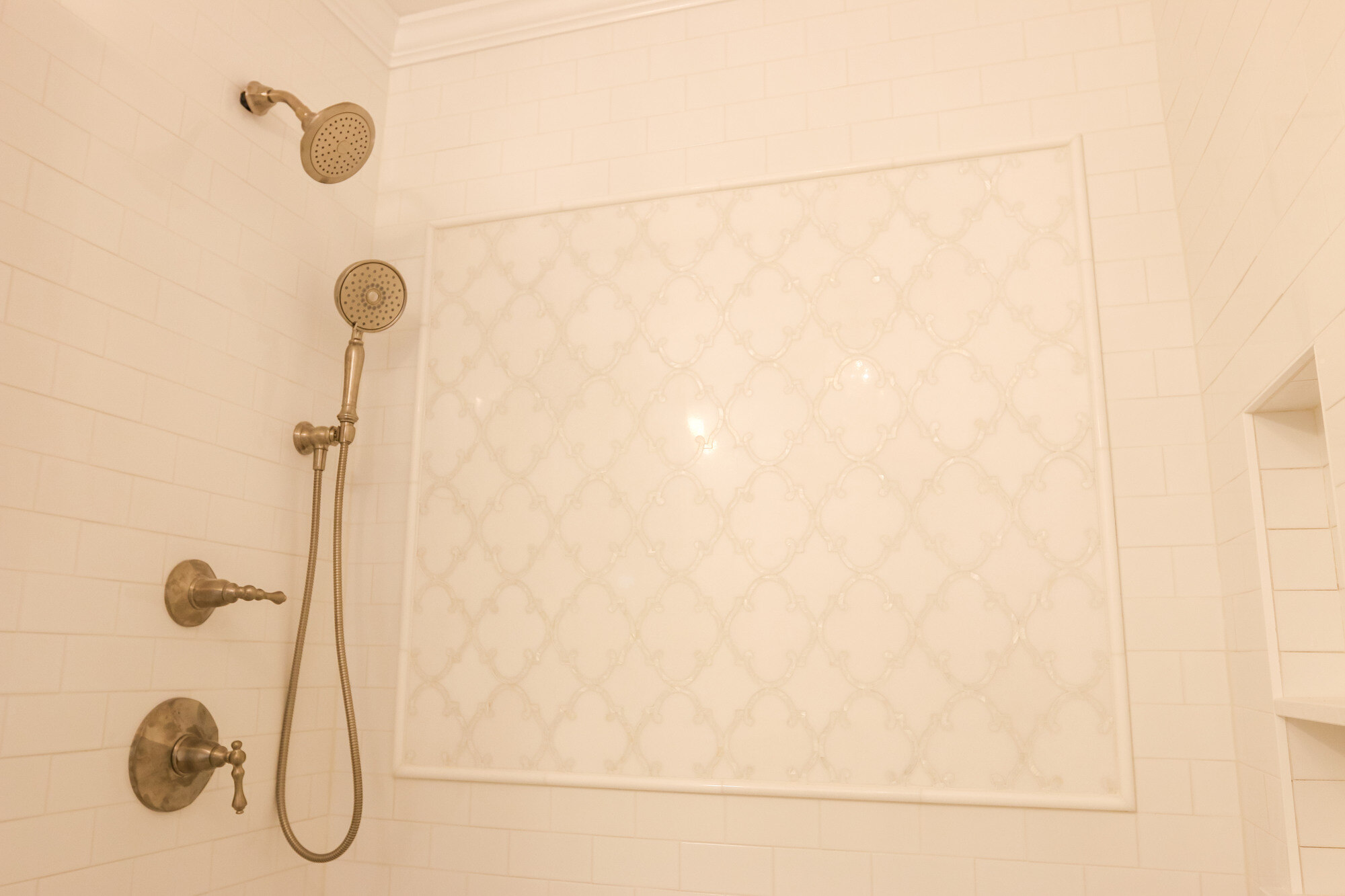 Classic white bathroom remodel in Newton, MA by Tom Curren, featuring vintage-inspired fixtures and accent wall tile
