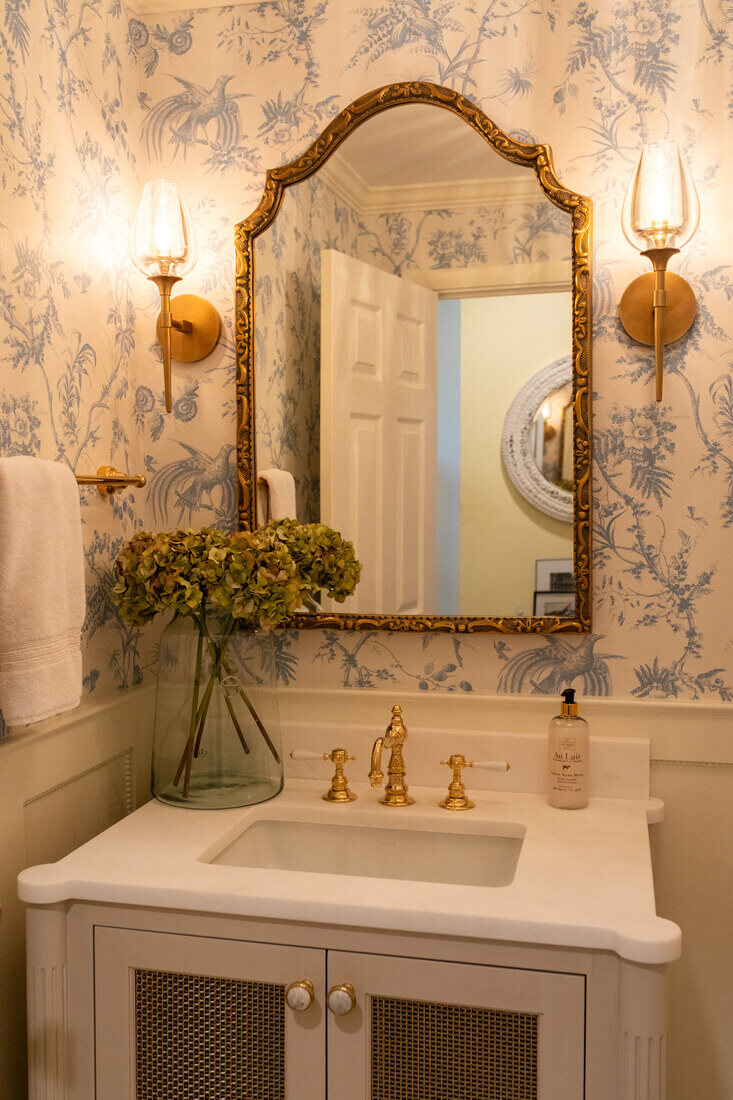 Classic powder room remodel in Newton, MA by Tom Curren, featuring vintage floral wallpaper and gold accents