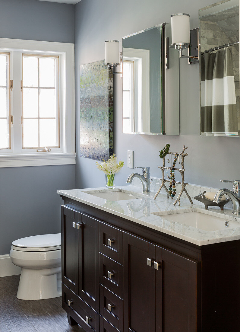 Luxurious bathroom renovation in Belmont, MA, with a rich espresso vanity, polished chrome faucets, and soft gray walls