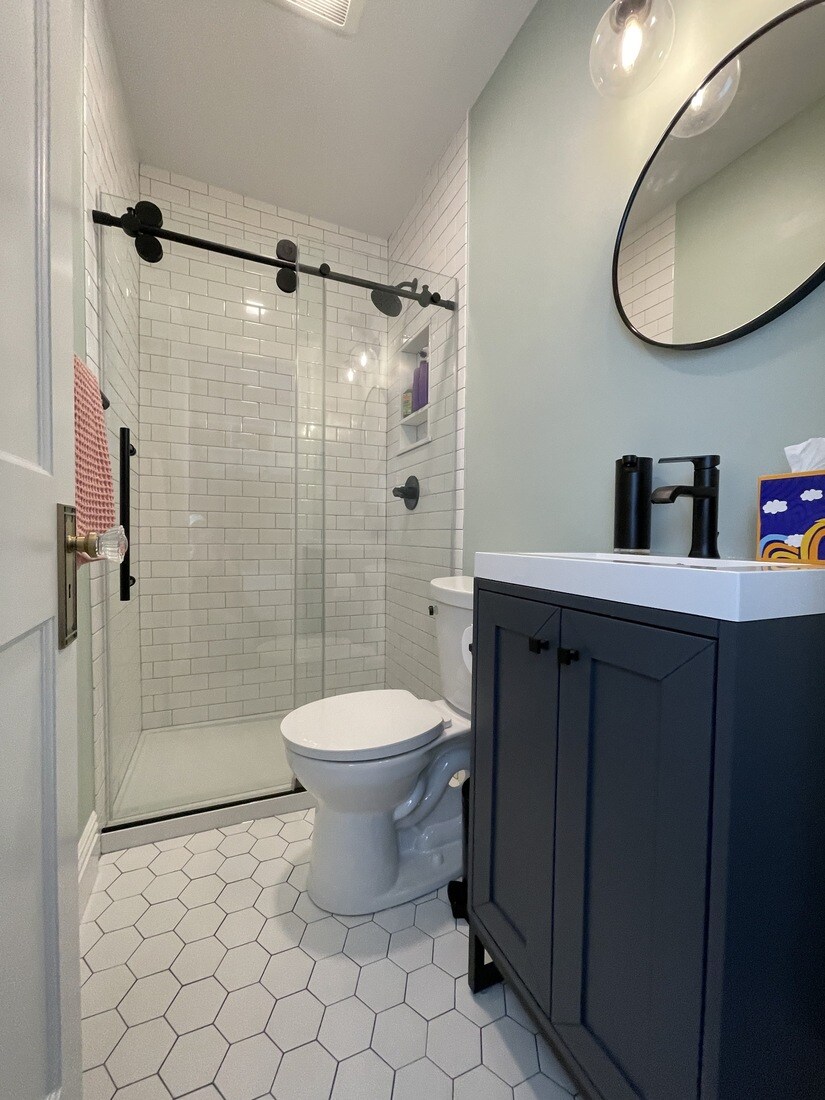 Small bathroom remodel in Watertown, MA by Tom Curren, featuring a stylish black-and-white design with hexagon tile flooring