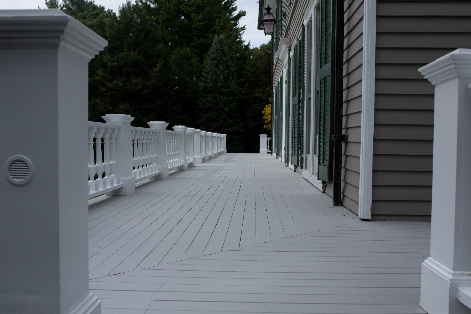 Close-up of a beautifully restored white deck with decorative railings, completed by Tom Curren in Lincoln, MA