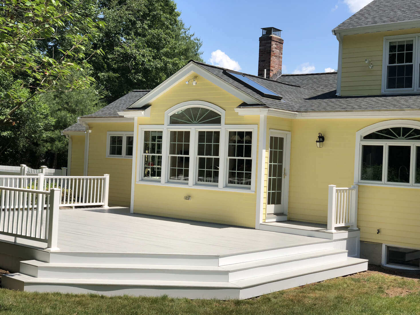 Newly painted deck with crisp white railings, part of a home improvement project by Tom Curren in Medfield, MA