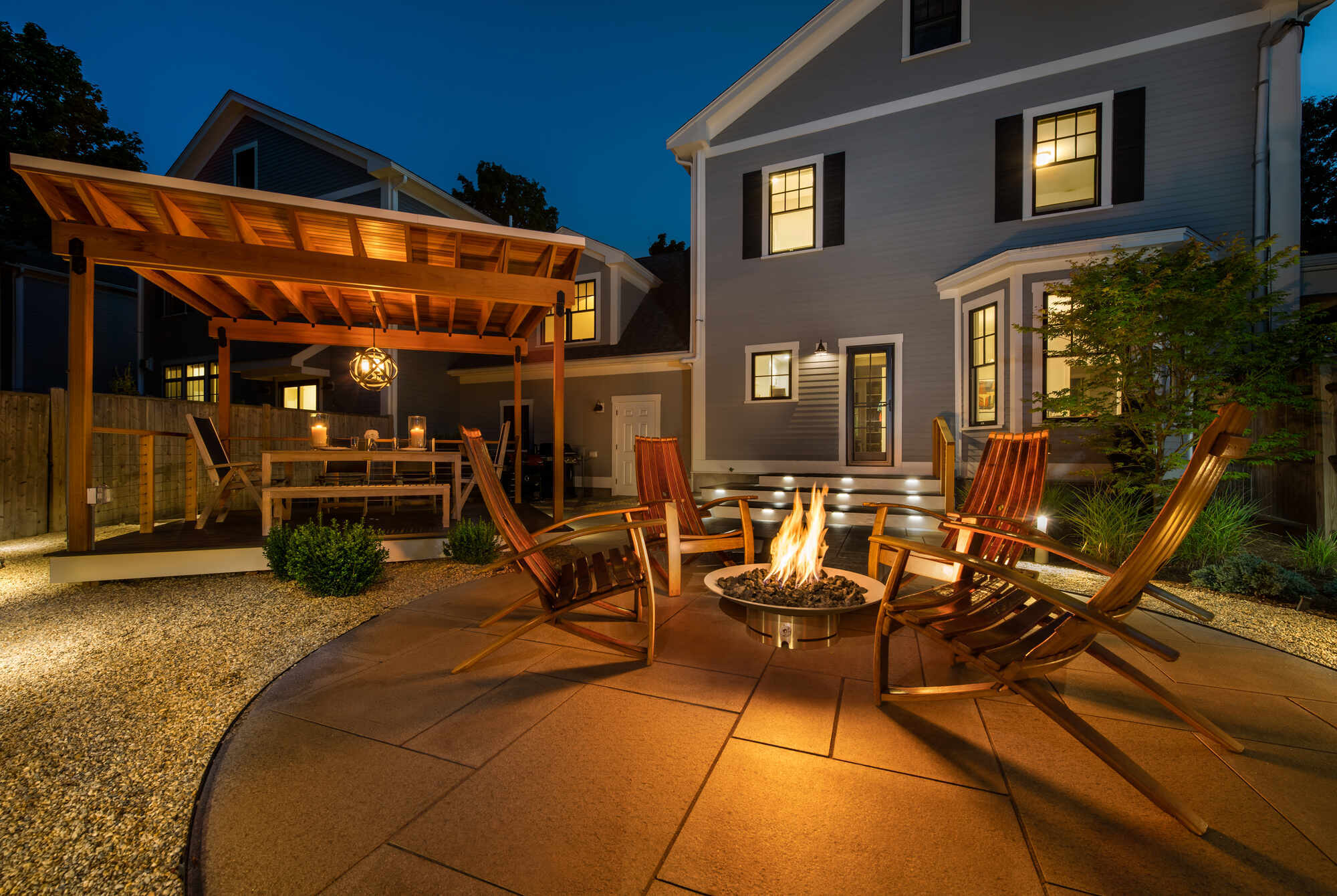 Modern backyard deck with built-in lighting and stone pavers, remodeled by Tom Curren in Auburndale, MA