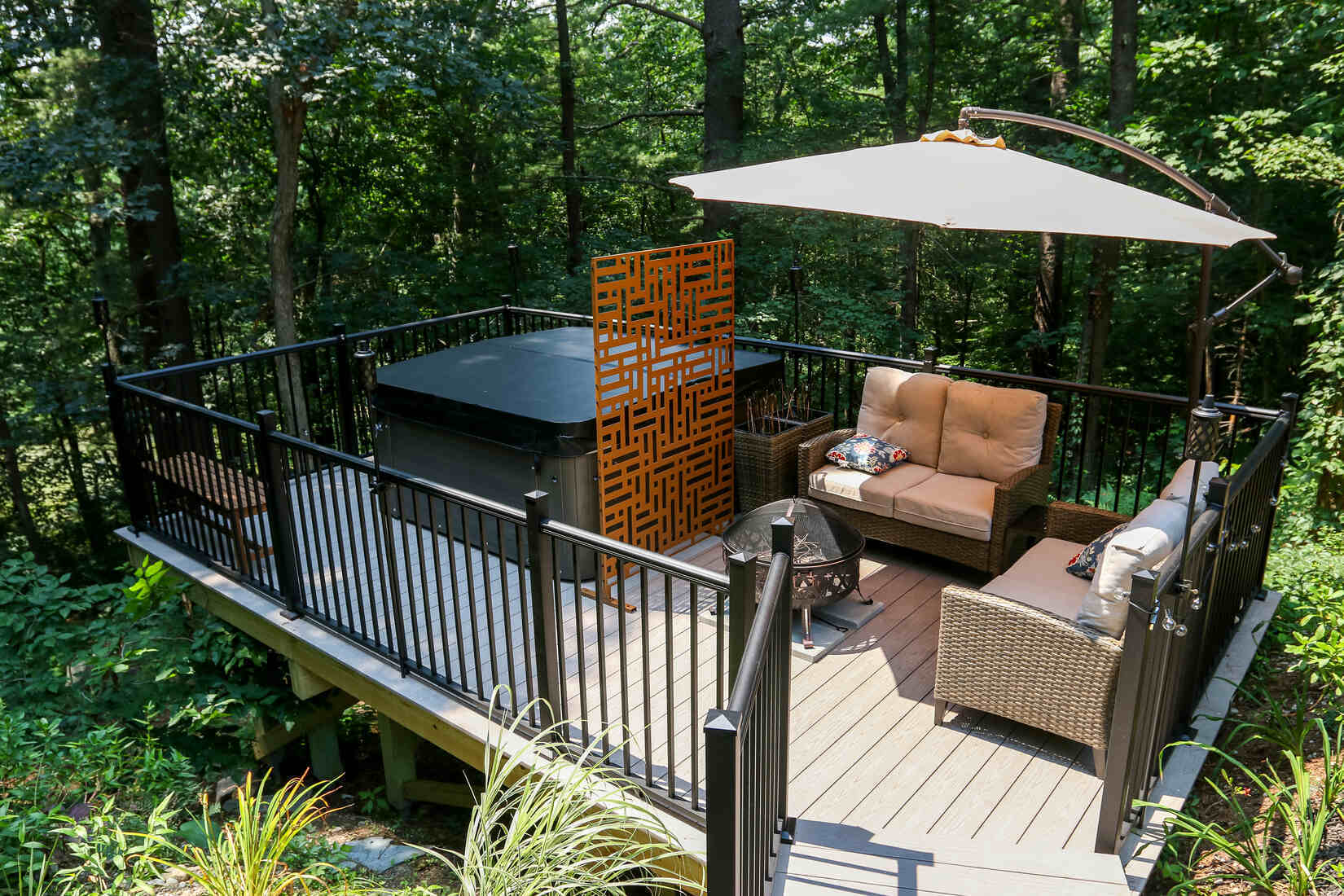 Custom-built elevated deck with black metal railings and a hot tub, constructed by Tom Curren in Medfield, MA