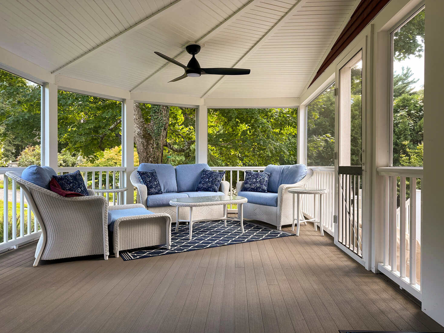 Spacious wooden deck with lounge seating and an umbrella, remodeled by Tom Curren in Medfield, MA