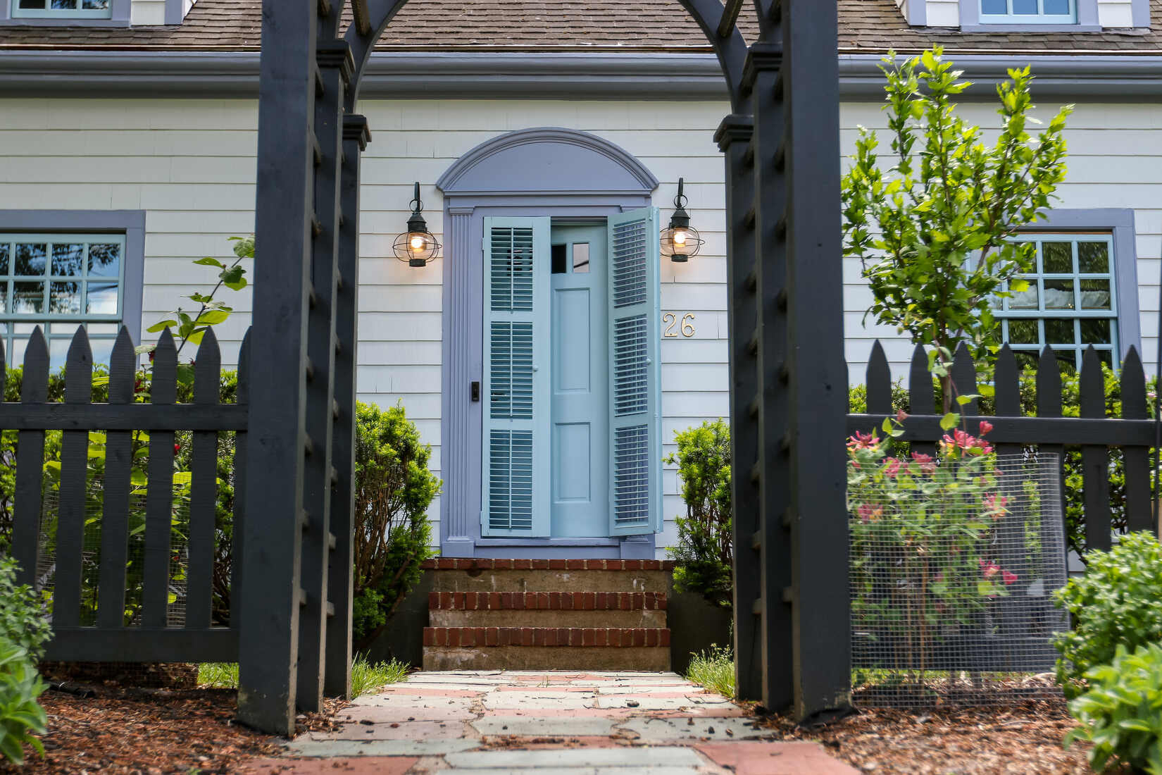 Charming Wellesley, MA home with a freshly painted light blue door and white siding by Tom Curren Companies