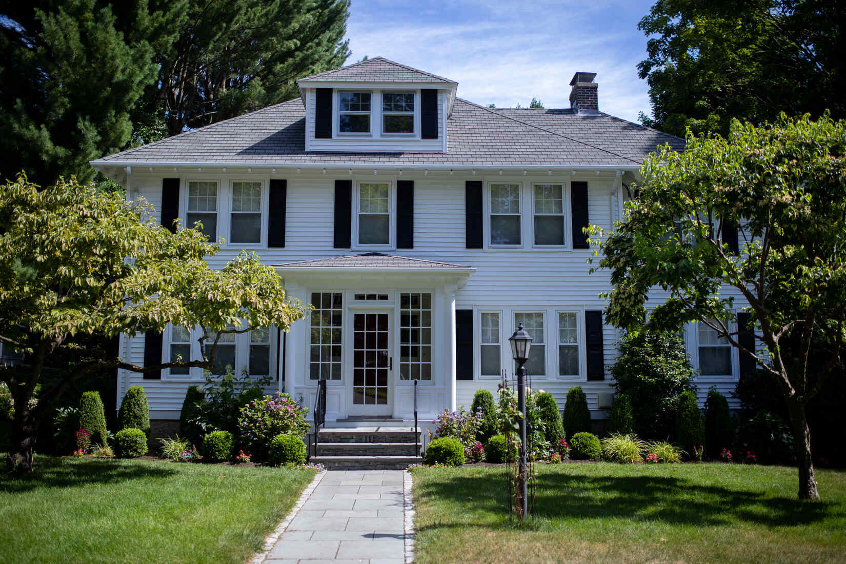 Crisp white colonial home in Auburndale, MA, featuring a fresh exterior paint job by Tom Curren Companies
