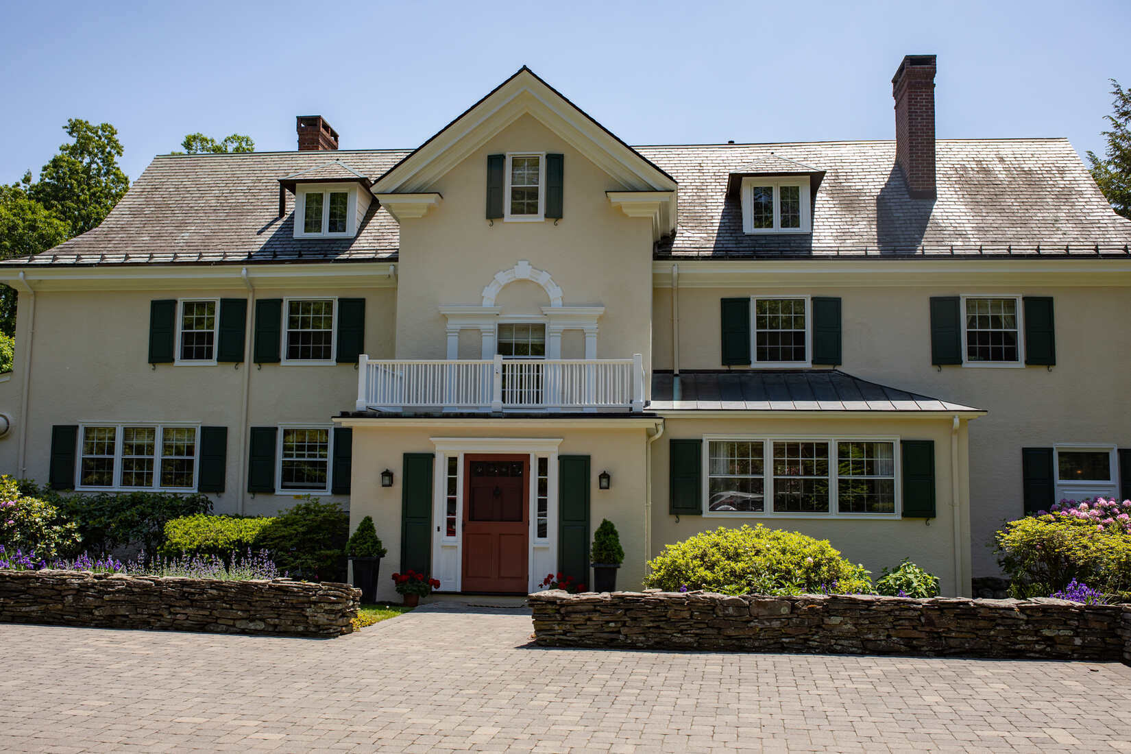 Elegant cream-colored home in Lincoln, MA, with fresh exterior stucco painting by Tom Curren Companies