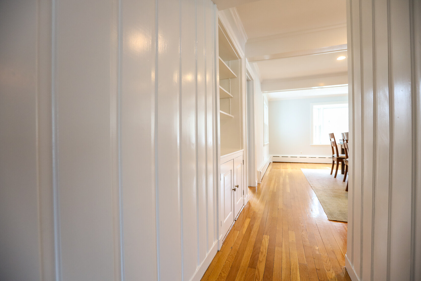 Elegant white-paneled hallway in Lincoln, MA, freshly painted to enhance the homes classic charm