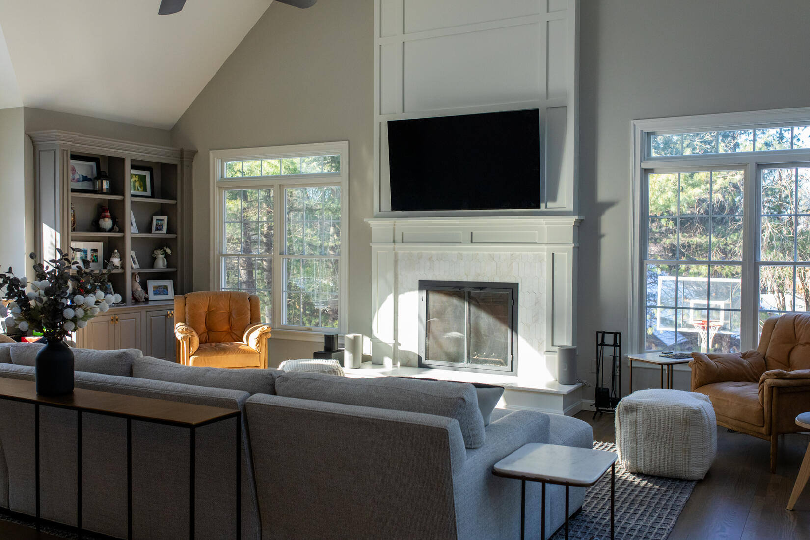 Newly painted living room with a white fireplace, built-in bookshelves, and natural light in Bedford, MA