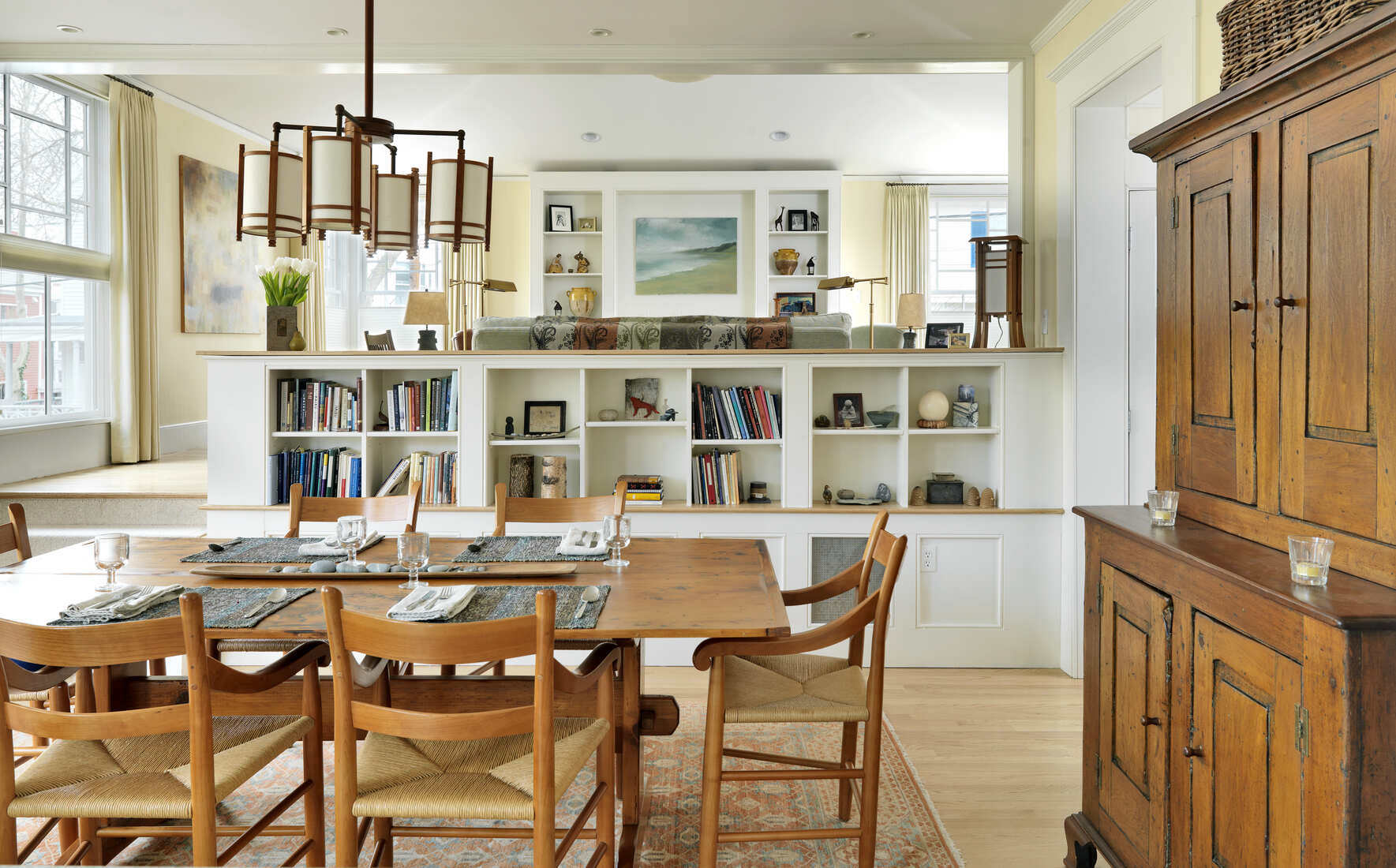 Open-concept dining and living space with fresh white paint and built-in bookshelves in Brookline, MA