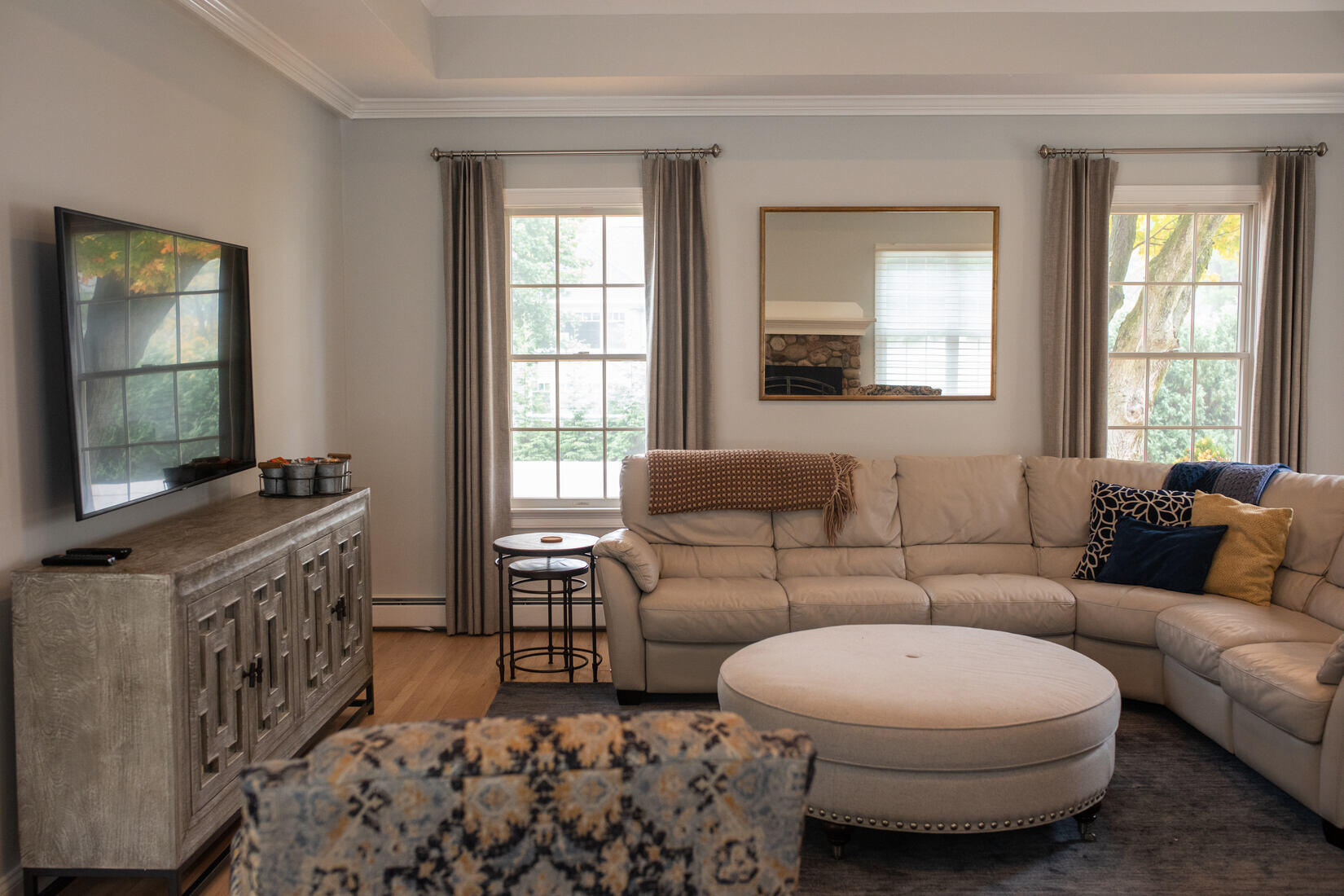 Spacious living room in Lexington, MA, with fresh wall paint, a large sectional sofa, and stylish neutral decor by Tom Curren