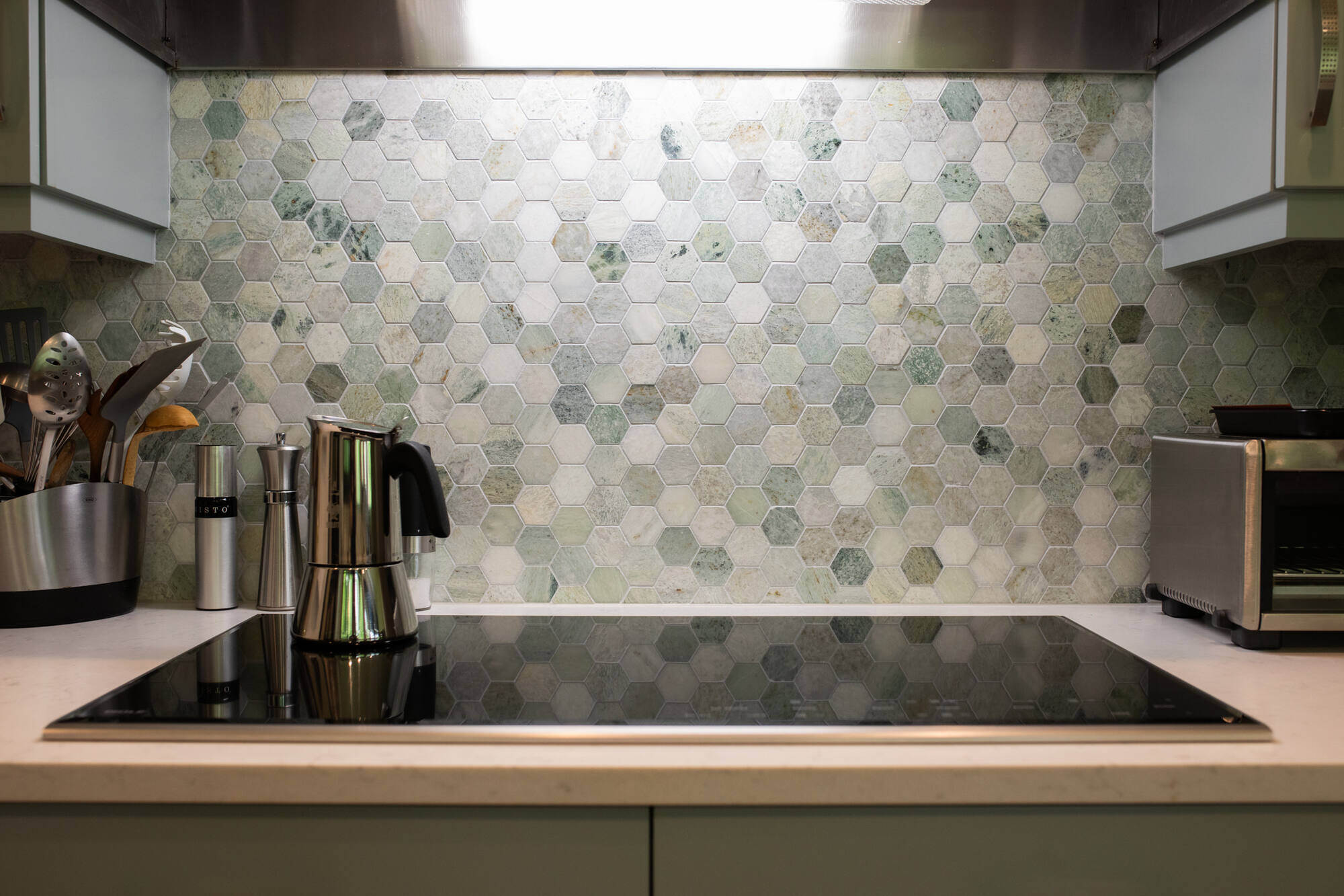 Kitchen remodel in Concord, MA by Tom Curren, featuring a unique hexagonal tile backsplash with stainless steel appliances
