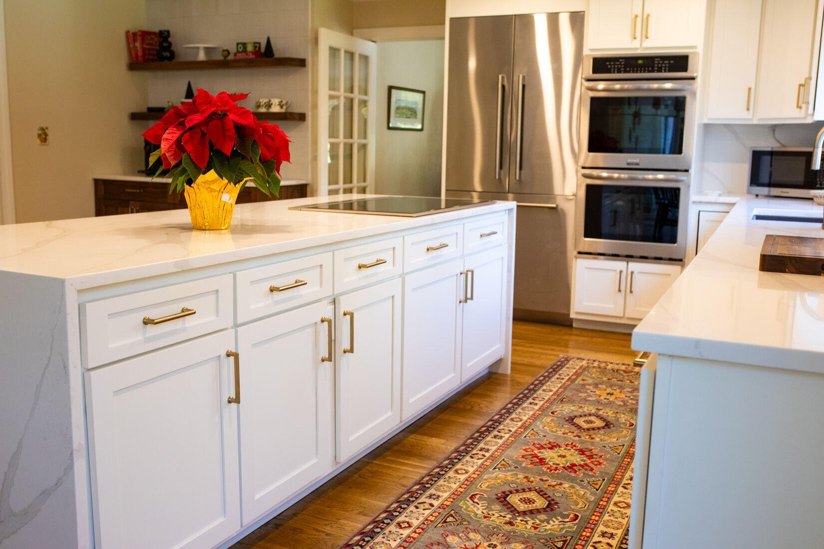 Waterfall counters and coffee station in a Sudbury, MA, kitchen remodel by Tom Curren, featuring floating wooden shelves and painted cabinets