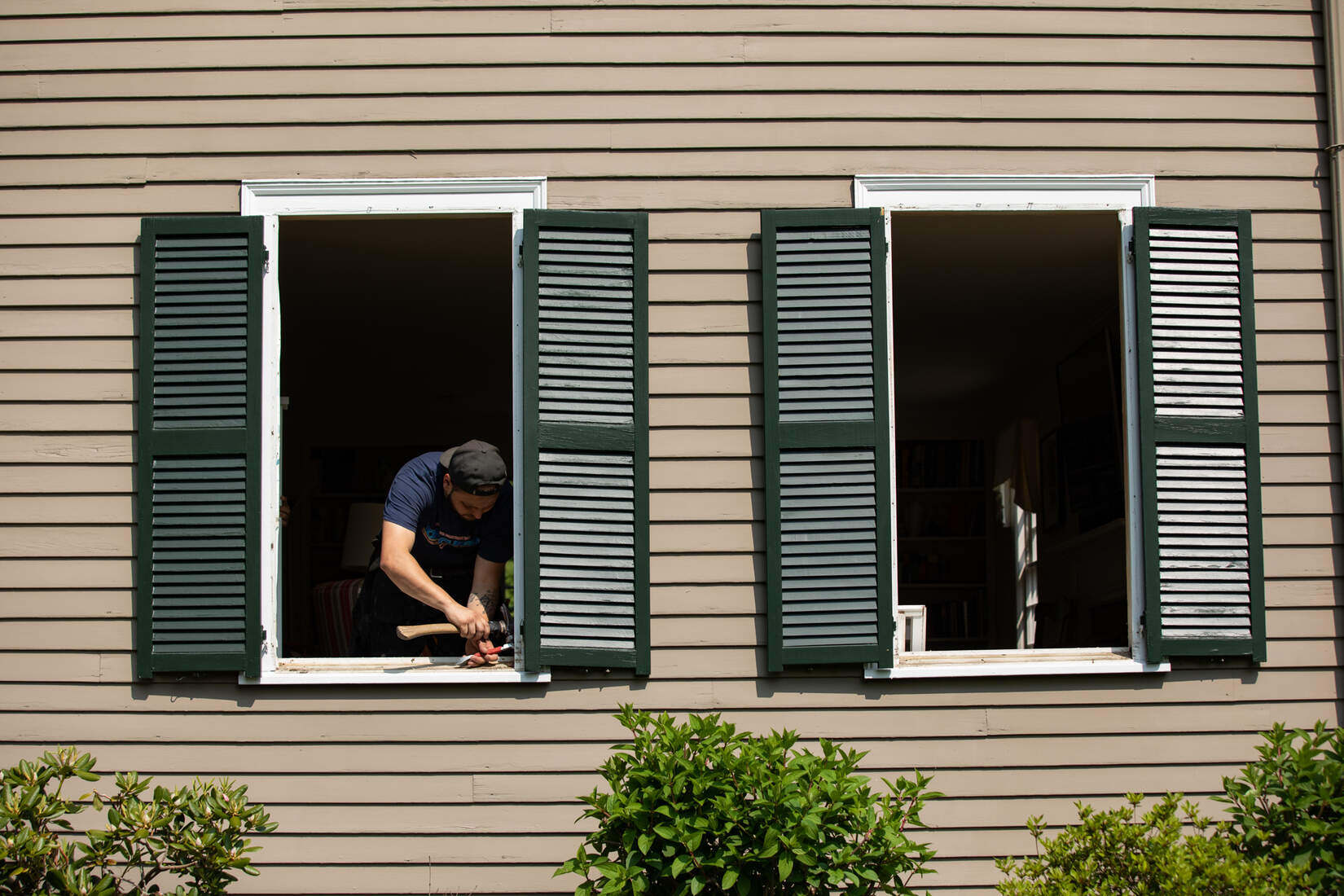 contractor from Tom Curren Company working on a window replacement in Needham, MA