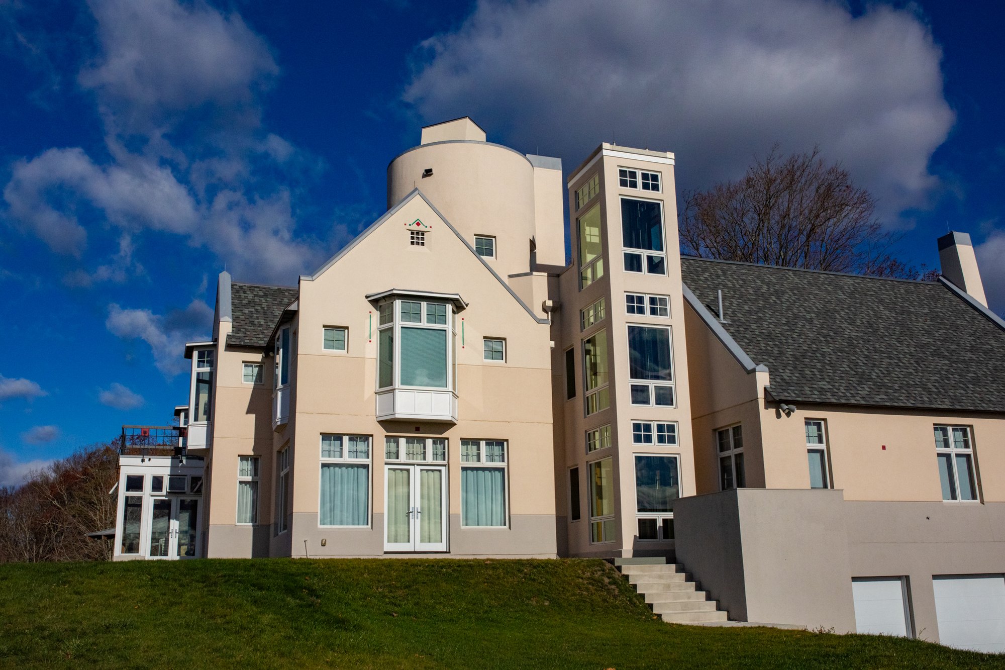 Addition of elevator shaft in modern home with new windows and stucco in Massachusetts