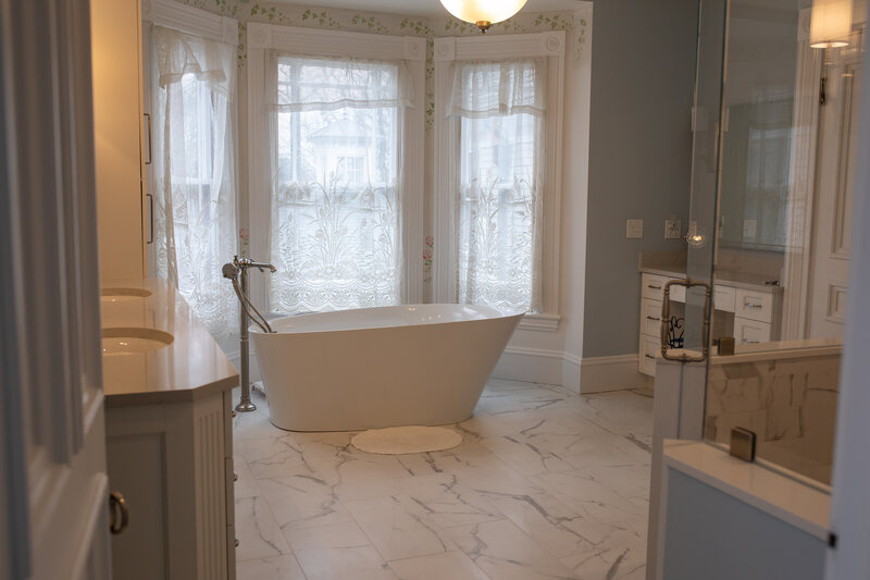 Modern upscale bathroom remodel in Wellesley with freestanding tub and makeup vanity