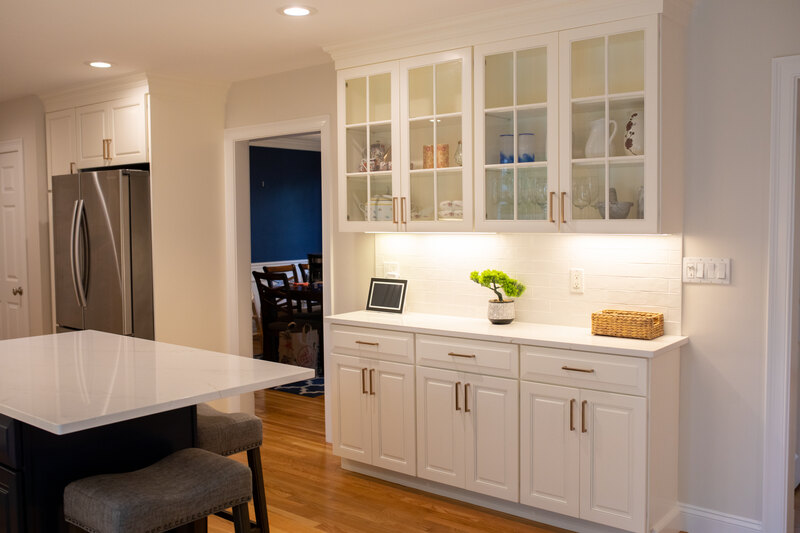 White upper and lower kitchen cabinets with gold finishes