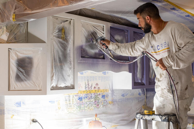 Tom Curren employee painting kitchen cabinets