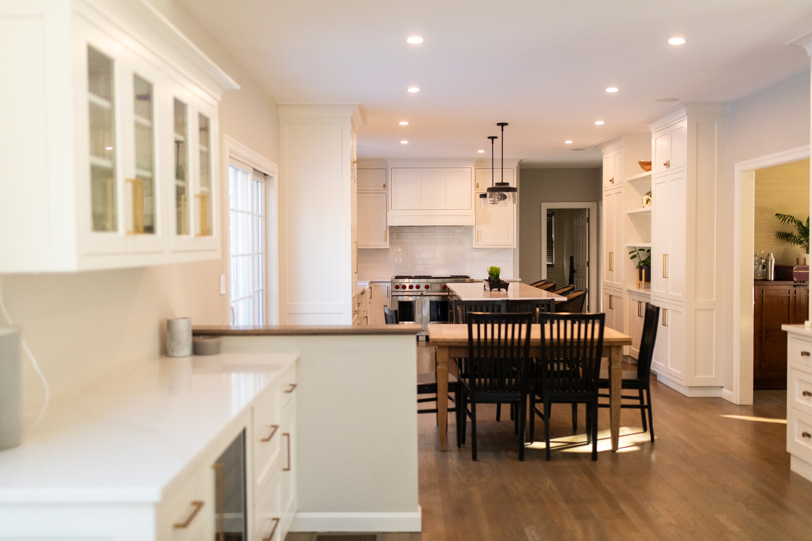 Bright living room remodel in Bedford, MA with vaulted ceiling, skylights, and white fireplace by Tom Curren Companies