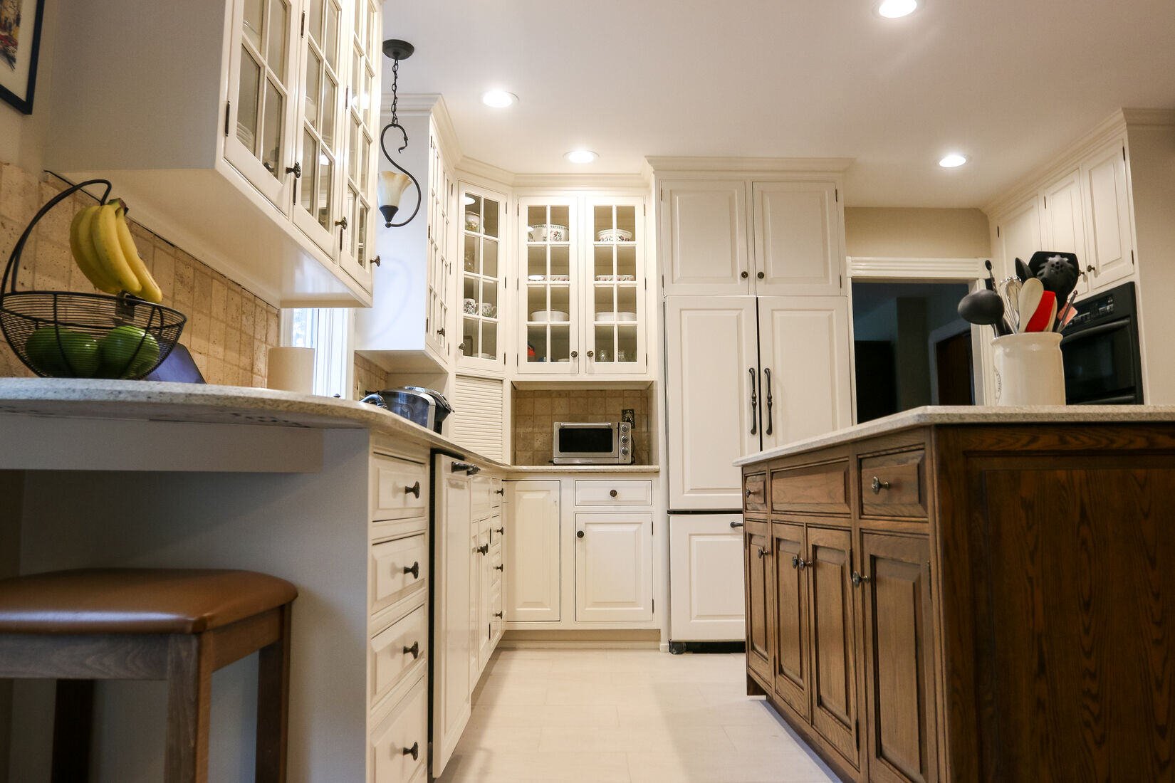 Custom kitchen renovation with a mix of white cabinetry and warm wood finishes in a West Metro Boston home