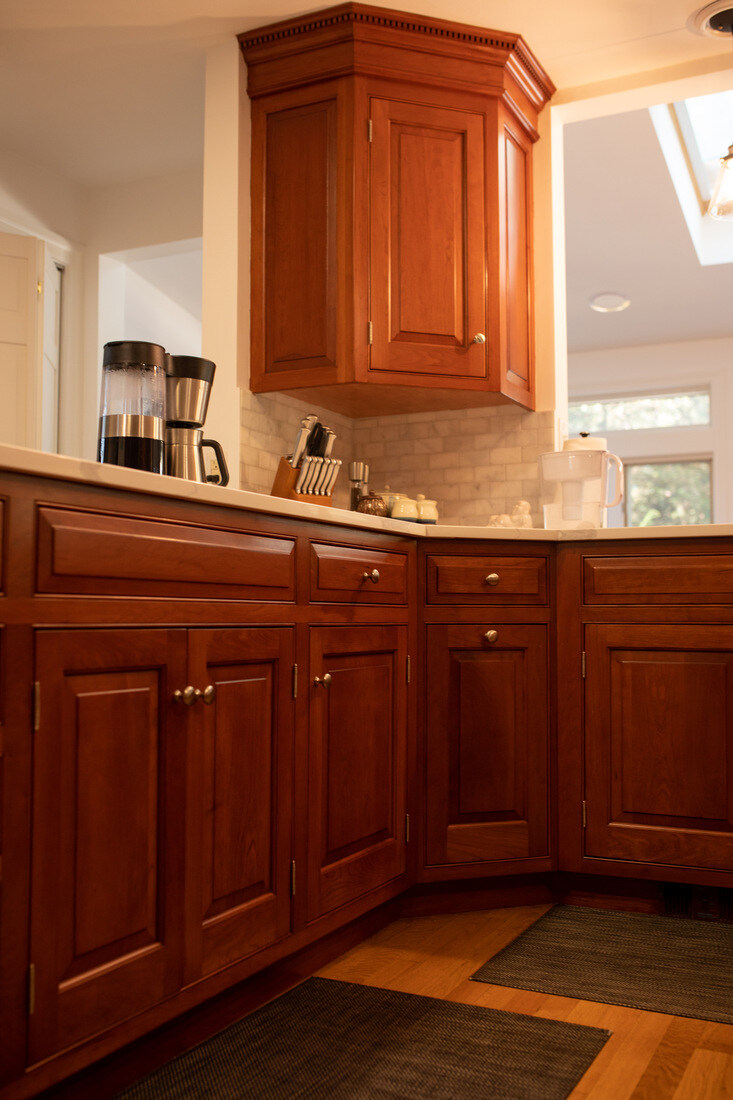 Warm wooden kitchen cabinets in a beautifully renovated kitchen by Tom Curren Companies in West Metro Boston