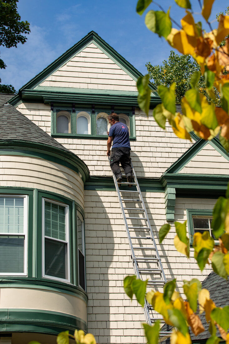 High-elevation carpentry inspection in Newton, MA, assessing home siding and window trim