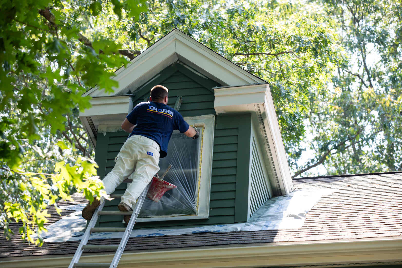 Tom Curren team applying fresh exterior trim paint to a home, ensuring a polished and clean look