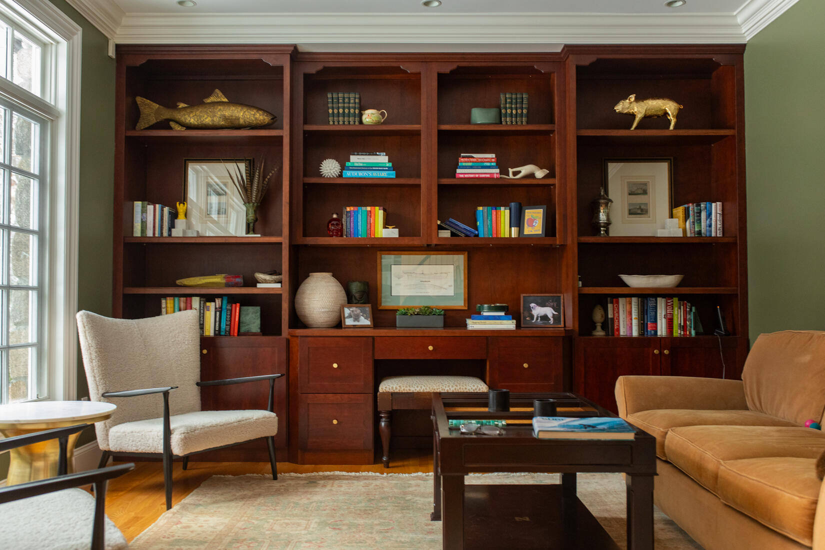 Classic home library in Weston, MA, with a rich wood bookcase and freshly painted green accent wall
