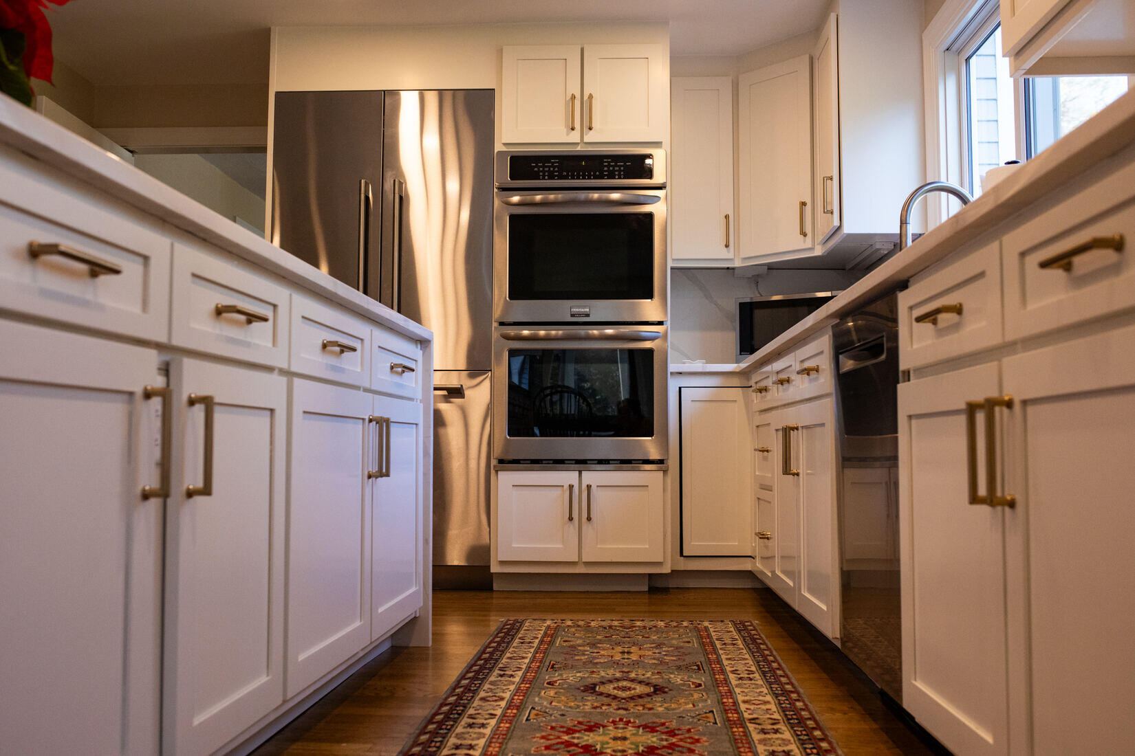 Elegant kitchen transformation in Sudbury, MA, with a large island, sleek white cabinets, and high-end stainless steel appliances