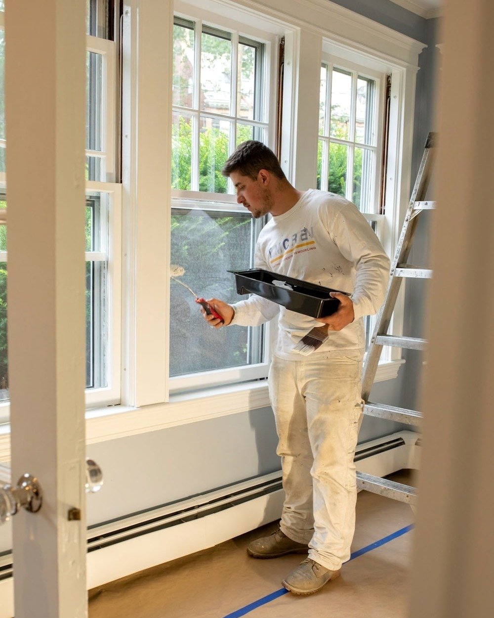 Tom Curren employee painting window sills white. Tom Curren employee painting window sills white.