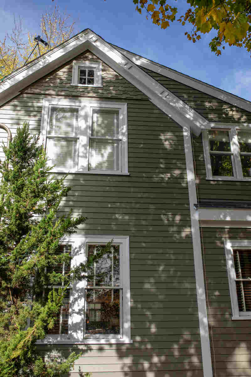 Exterior view of a house with green siding and white trim.